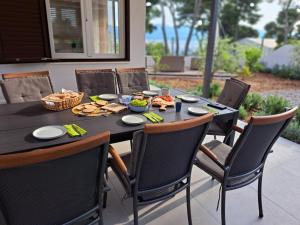 苏提万Apartment Dalmatia Holidays Adventure的一张黑色桌子,上面有椅子和食物