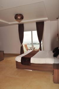 乌提Vanam Holidays Inn的一间卧室设有一张床,享有海景