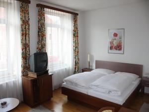 Frankenmarkt嘎斯霍夫波斯特酒店的一间卧室配有一张床和一台电视。