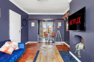 达特福德Home at The Brent的客厅配有蓝色的沙发和电视