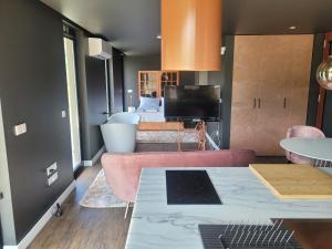 蓬蒂-达巴尔卡INFINITY HOUSES的客厅配有粉红色的沙发和电视