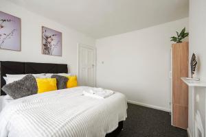 达特福德Home at The Brent的一间卧室配有白色的床和黄色及灰色枕头