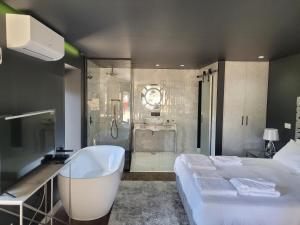 蓬蒂-达巴尔卡INFINITY HOUSES的一间带一张床、一个浴缸和淋浴的浴室