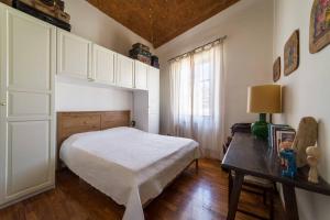 普拉托Lovely apartment in Tuscany, near Florence的一间卧室配有一张床、一张桌子和一个窗户。