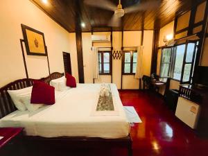琅勃拉邦Ban Lakkham River View的一间卧室配有两张带红色枕头的床