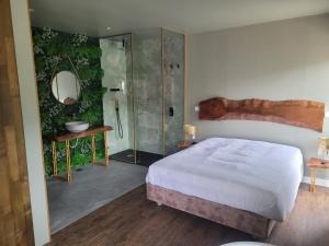 蓬蒂-达巴尔卡INFINITY HOUSES的一间卧室设有一张床和一个玻璃淋浴间
