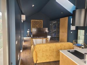 蓬蒂-达巴尔卡INFINITY HOUSES的客厅拥有蓝色的墙壁和黄色的沙发