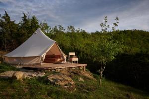 拉亚蒂科Agricola Ombra - Tents in nature的一个带木甲板的白色帐篷