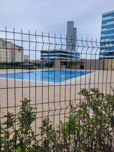 伊斯坦布尔Residence 5 etoiles Orya Park avec piscine的一座游泳池,位于围栏后面,设有一座建筑