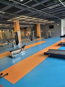 伊斯坦布尔Residence 5 etoiles Orya Park avec piscine的一间设有橙色和蓝色地板及椅子的健身房