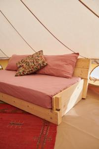 拉亚蒂科Agricola Ombra - Tents in nature的帐篷内的一张床位,上面有两个枕头