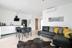 扎马迪Family Apartments by Hi5 - Zamardi的一间带黑色沙发的客厅和一间厨房