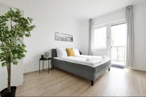 扎马迪Family Apartments by Hi5 - Zamardi的一间白色的卧室,配有床和盆栽植物