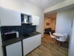 毕尔巴鄂B75 Apartments Bilbao的厨房配有白色橱柜和桌椅