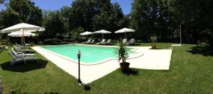 塞吉阿诺安蒂科卡萨莱波祖罗旅馆的庭院内带椅子和遮阳伞的游泳池
