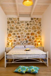 阿基欧斯尼古拉斯Althea Villa by breathtaking view的一间卧室设有一张床和石墙