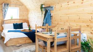 Holme upon Spalding MoorDwell on the Moor的小木屋内的卧室,配有一张床和一张桌子