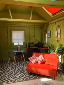 KentLepine- Holiday apartment in sunny Folkestone的客厅配有红色的沙发和桌子