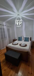 维拉·雷阿尔Casa do Espadanal的一间卧室配有一张大床和一个吊灯。