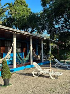巴拉那瓜Pousada Pé Na Areia - ilha do mel的房屋前设有吊床和长凳