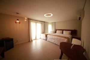 马拉戈日Pousada Rangai的酒店客房设有两张床和窗户。