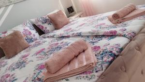 里耶卡Apolonija的一张带花卉床罩和毛巾的床