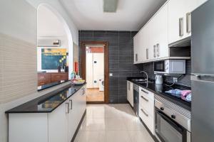 普拉亚布兰卡Villa Alegria的厨房配有白色橱柜和黑色台面