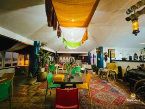 八打雁Utopia Island Resort的用餐室配有五颜六色的椅子和桌子