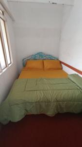 BasoRumah Gadang Simarasok的小型客房内的一张床位。