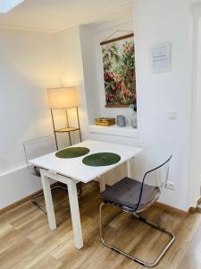 科隆科隆城市公寓 的客房内的一张白色桌子和两把椅子