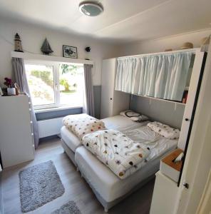 霍勒姆Vakantiehuis Hollum Ameland dichtbij strand en met ruime tuin - Ameland39 nl的一间卧室设有两张床和大窗户
