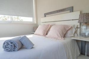 维拉诺瓦德卡塞拉Lightbooking Praia Fabrica Algarve的卧室配有白色床和粉红色枕头