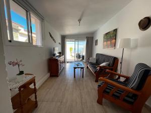 塔科龙特Lightbooking Agua Garcia Tacoronte con terraza的客厅配有两把椅子和一张沙发