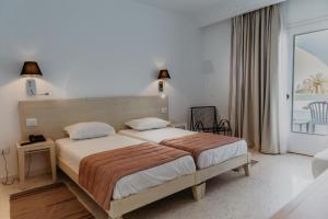 塔格梅斯Hotel Bougainvillier Djerba的一间卧室设有一张床和一个大窗户