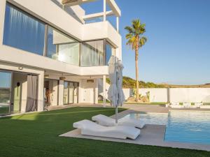 赫雷斯-德拉弗龙特拉Lightbooking Montecastillo Moto GP的一座带游泳池和棕榈树的大型白色房屋