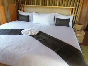 ChobeXhabe Safari Lodge Chobe的一张白色的大床,上面有连衣裙