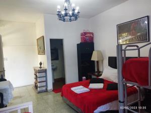 奥利沃斯hostel olivos的一间卧室配有一张带红色毯子的床