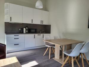 巴特多布兰Ferienwohnung Bad Doberan - mit Garten und Terrasse - 2023 neu renoviert的厨房配有木桌和白色橱柜。