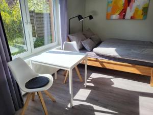 巴特多布兰Ferienwohnung Bad Doberan - mit Garten und Terrasse - 2023 neu renoviert的客房设有一张床、一张桌子和一张桌子。