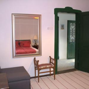 包道乔尼托毛伊Villa Délibáb的一间卧室配有镜子、椅子和一张床