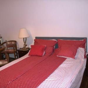 包道乔尼托毛伊Villa Délibáb的红色和白色的床,上面有红色枕头