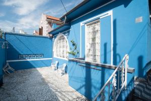 圣保罗Aconchego Azul Suítes Vila Mariana的蓝色的房子,设有通往窗户的楼梯