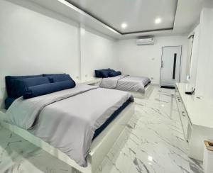 跋麒Family Cliff House - private jacuzzi with beach views的配有白色墙壁和大理石地板的客房内的两张床