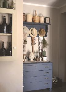 福贾B&B La Casa Pugliese的一间设有蓝色梳妆台、帽子和眼镜的房间