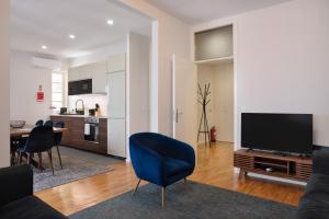 波尔图Invicta Premium - Downtown apartment的客厅配有电视和蓝椅