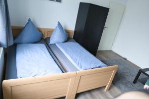 施内沃丁根Heide Ferienwohnung Süd的一张床上有蓝色枕头的睡床