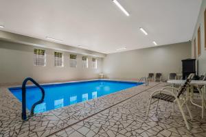 托皮卡SureStay Plus Hotel by Best Western Topeka的一个带桌椅的房间的游泳池