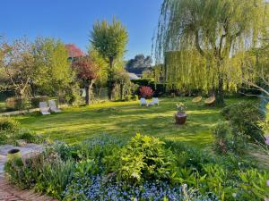 马尔康巴勒尔La Demeure Marcquoise的种有长椅和树木及鲜花的花园