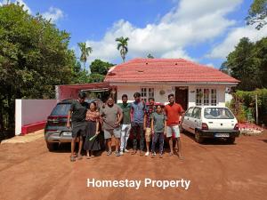 SomvārpetHomestay In Coorg Doddakallu Betta的一群站在房子前面的人