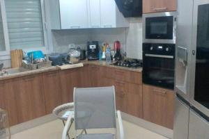 莫纳斯提尔Villa ilian的厨房配有木制橱柜和椅子